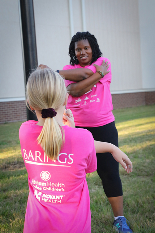 Girls on the Run coach and participant doing arm stretches