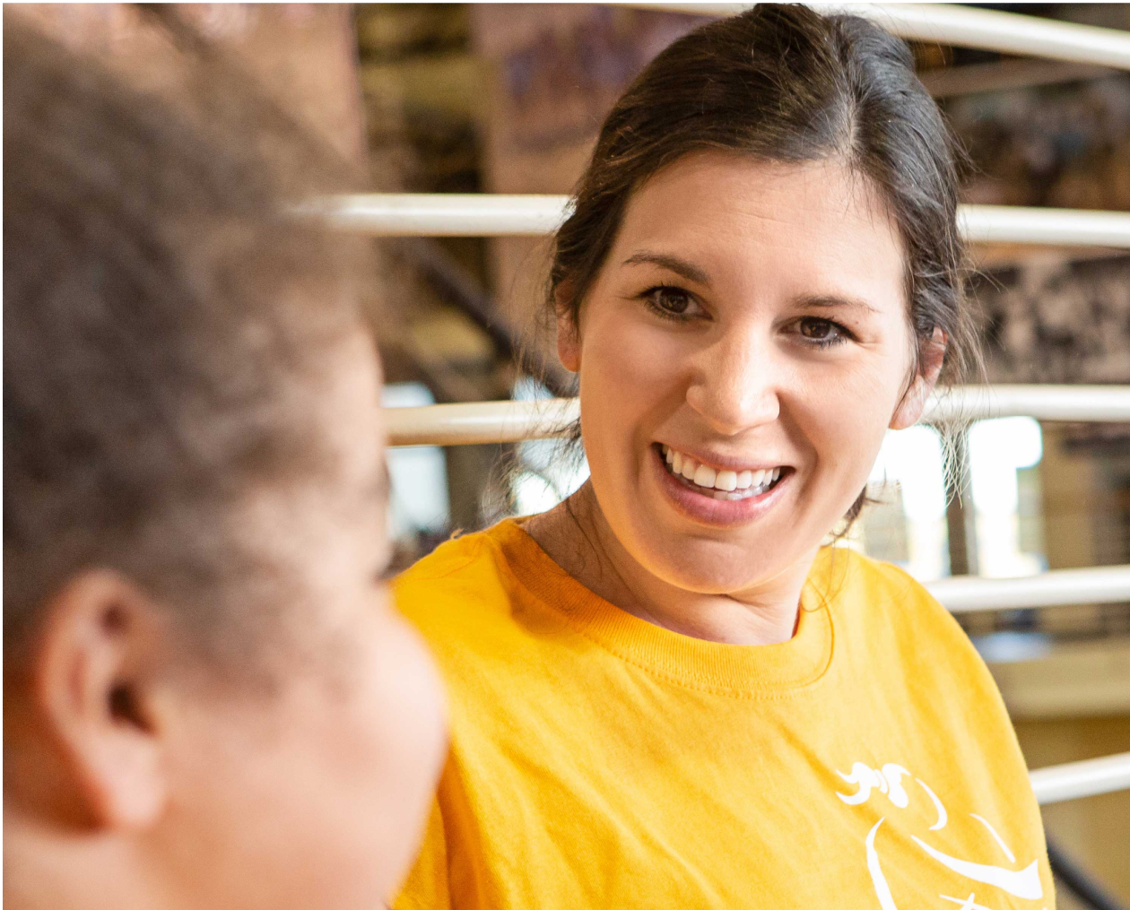 Girls on the Run coach is smiling at one of the program participant outdoors