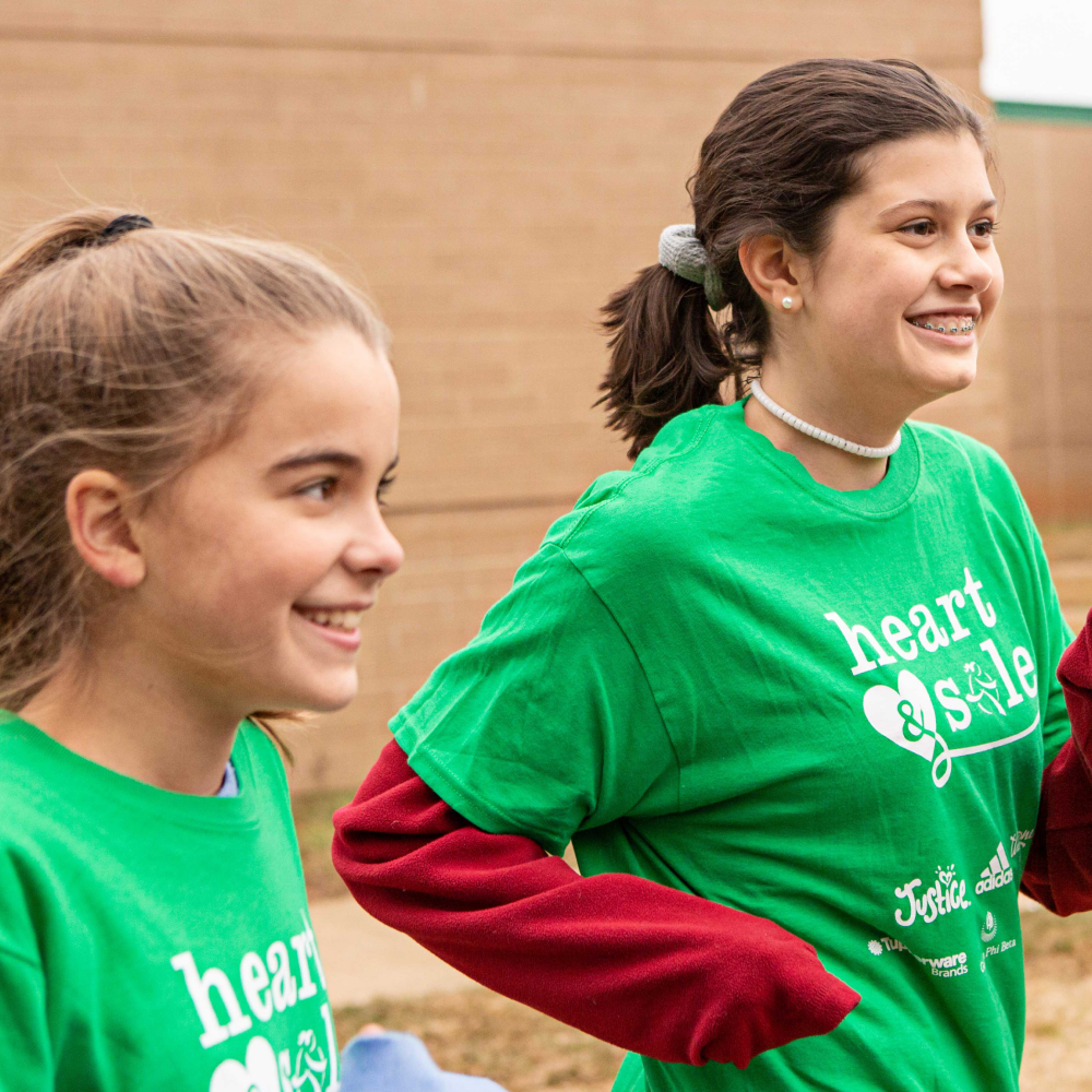 Two Heart and Sole participants smile while running in the program
