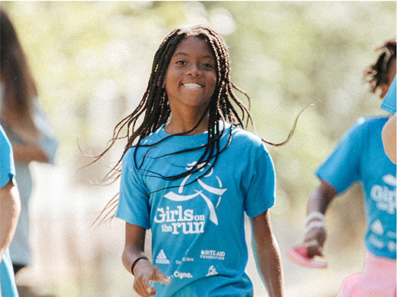 a Girls on the Run program participant smiles oustide during practice 